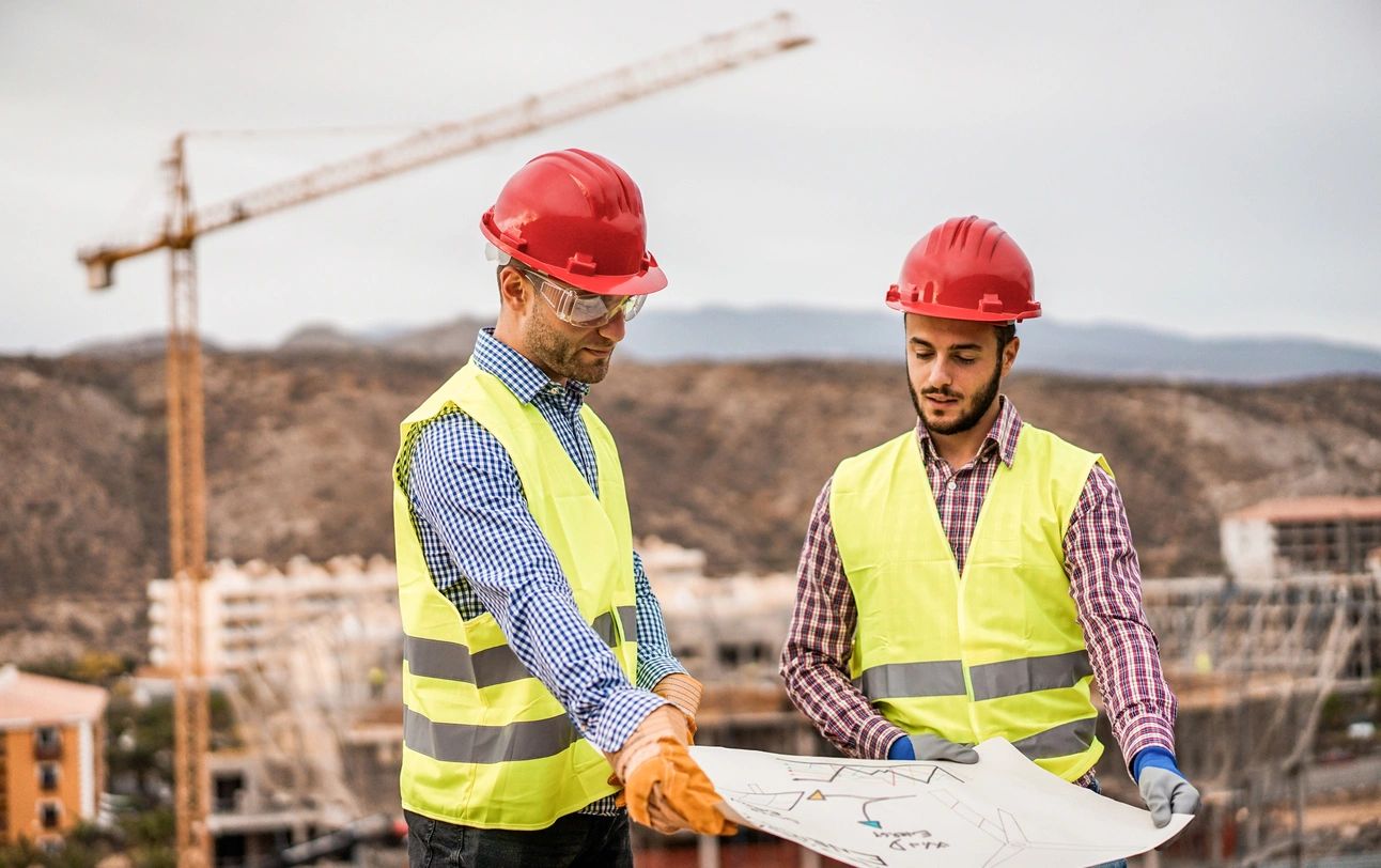 Two engineer holding blue print